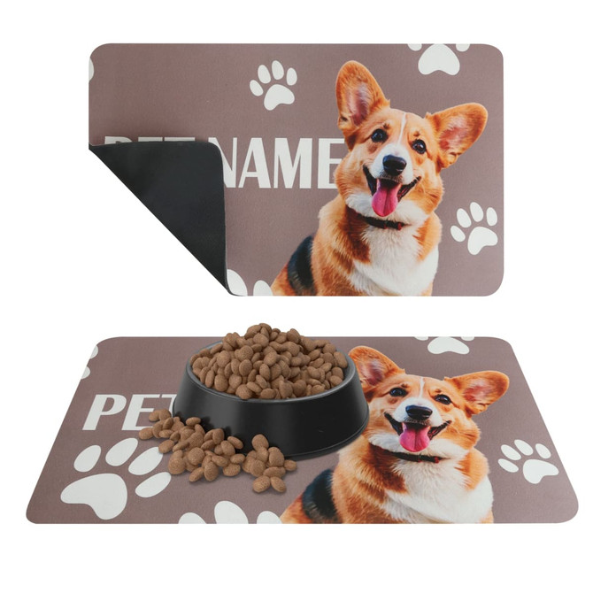 A pet feeding mat featuring a brown background with a corgi's face and paw print designs. It has a logo.
