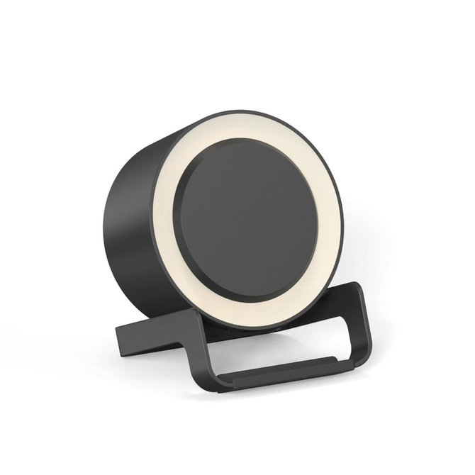 A round black night light speaker with a wireless charging stand. The product features a light ring around the top edge.