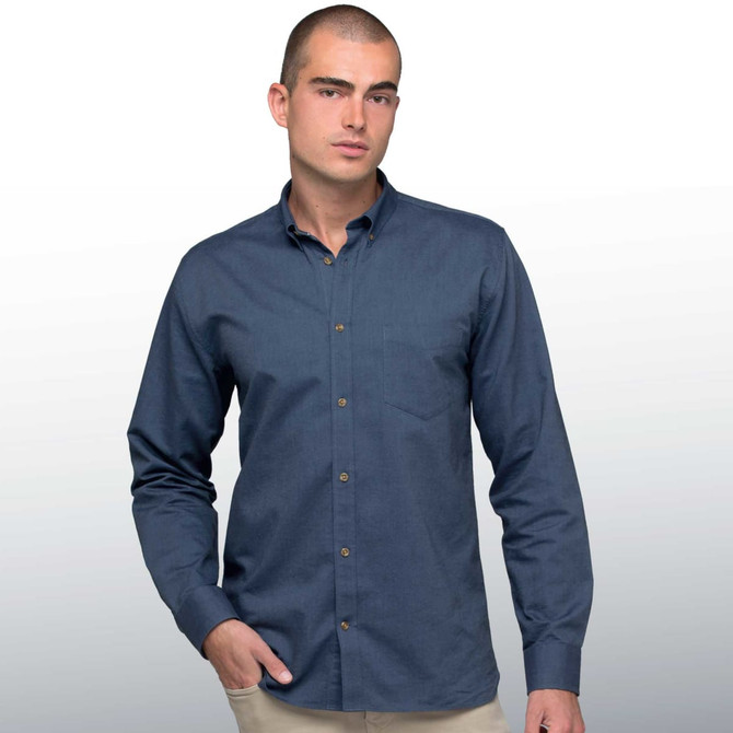 A man models a navy blue button-up shirt, featuring long sleeves and a button-down collar. The shirt has a logo.