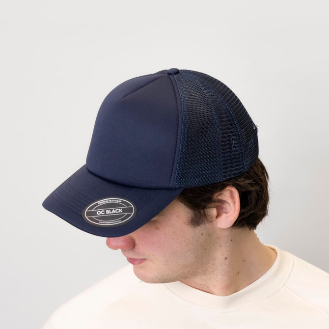A navy trucker cap with a foam front and mesh back, featuring a logo on the front.