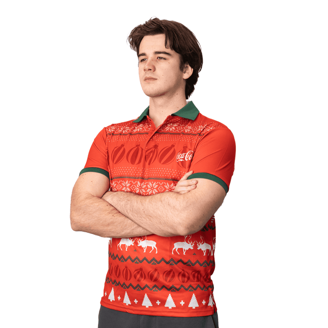 A red polo shirt with green accents features festive patterns and a logo. Perfect for holiday-themed events.