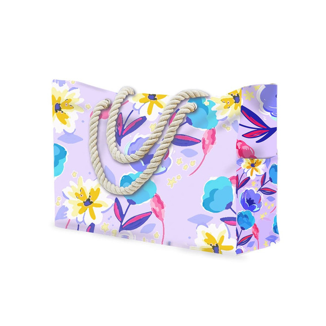 A floral-patterned beach bag in pastel purple, featuring colourful flowers and sturdy rope handles.
