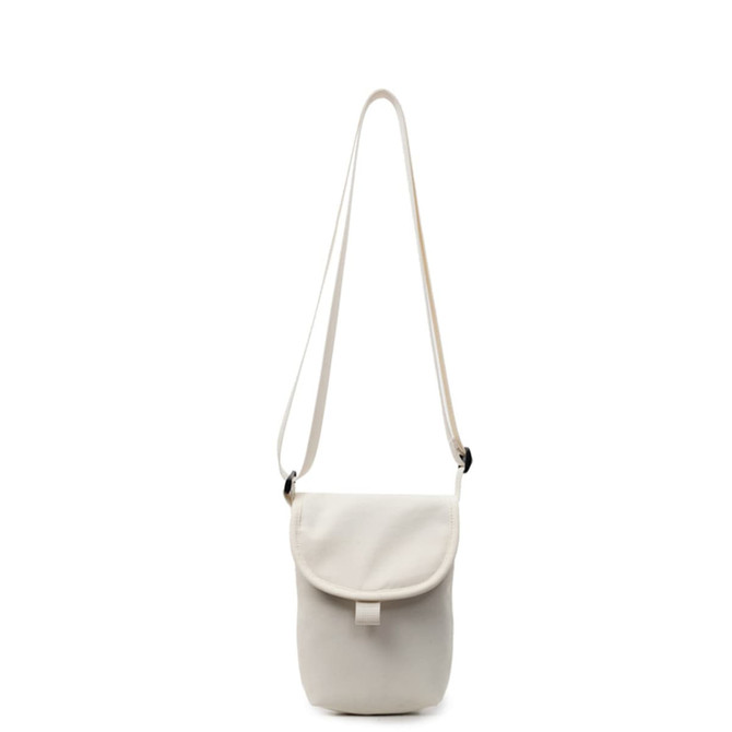 A small size canvas shoulder bag in cream colour with a flap and adjustable strap. It features a logo.
