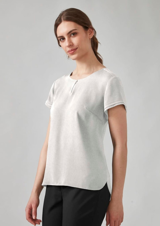 A short sleeve blouse in light grey, featuring a rounded neckline and a casual fit, displayed on a model.