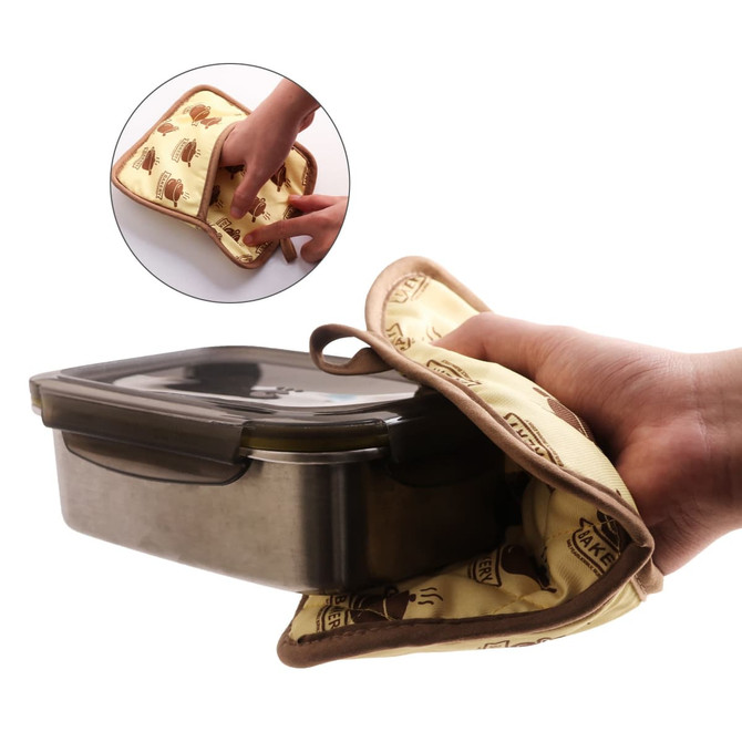 A large quilted pot holder in cream with brown designs, being used to hold a metal container.