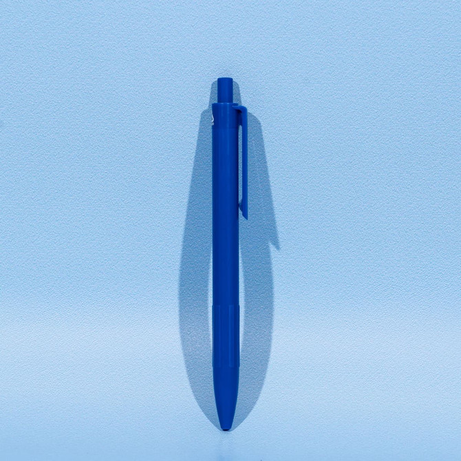 A blue plastic ballpoint pen with a clip, set against a light blue background.