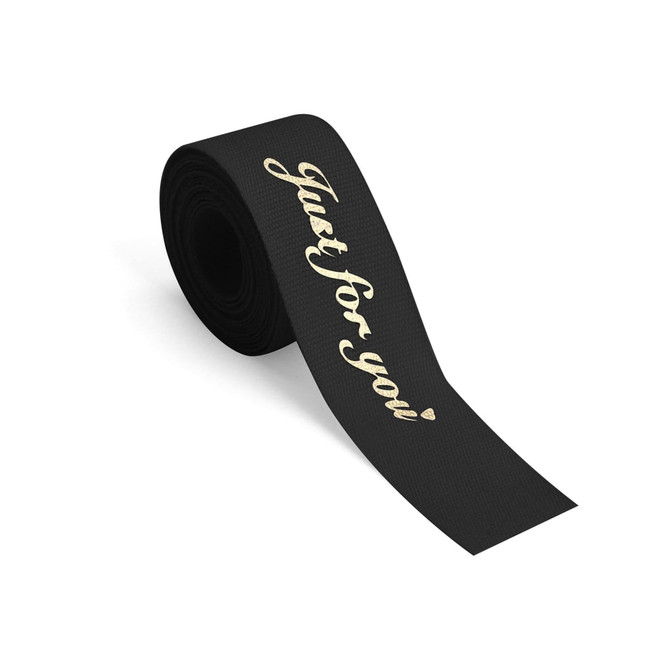 A roll of black cotton ribbon featuring hot stamping text in gold saying "Just for you."