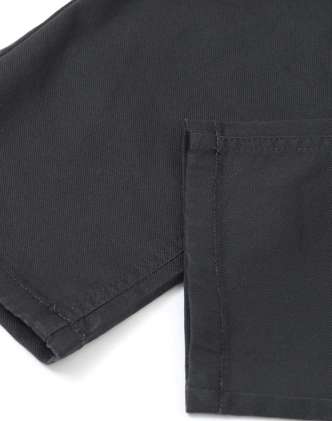 A close-up of black flexi chino pants showcasing the fabric texture and stitching details.