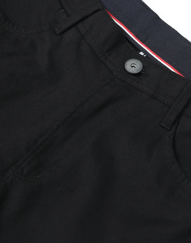 Black flexi chino pants with a button closure and pockets, featuring a contrasting waistband and logo.