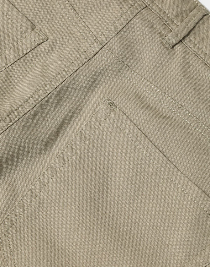 A close-up of khaki ladies' chino pants showcasing detailed stitching and pocket design. The pants have branding present.