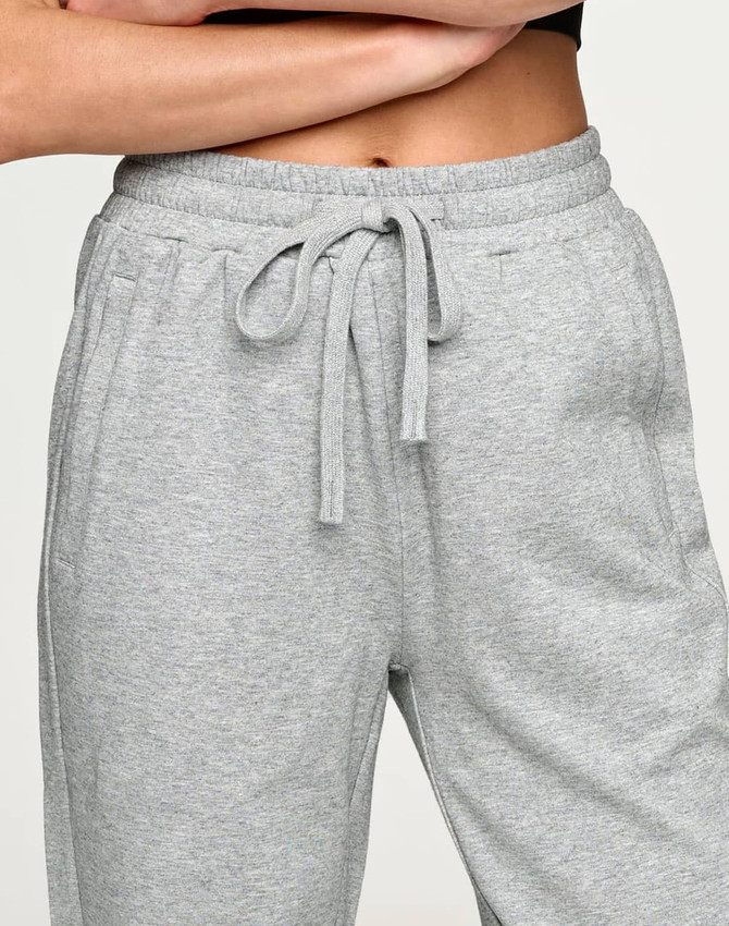 Grey unisex sweatpants with an elastic waistband and drawstring, featuring side pockets and a logo.