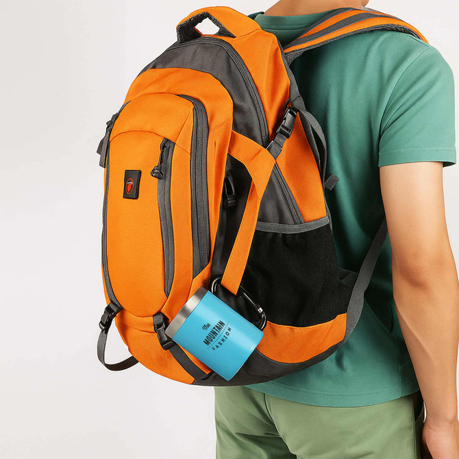 A drink bottle in a blue recycled stainless steel finish with a carabiner handle attached to an orange backpack.