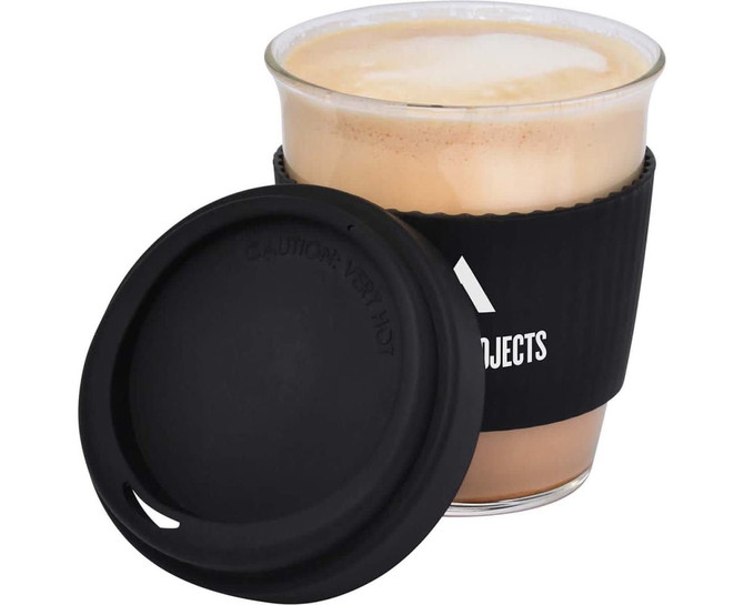 A drink cup featuring a black silicone sleeve and lid, filled with a frothy coffee beverage.