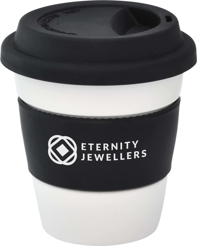 A reusable ceramic mug in white with a black silicone lid and sleeve, featuring a logo.