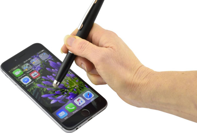 A black stylus pen held in a hand, touching the screen of a smartphone displaying a floral background.