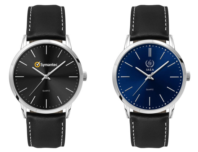 A men's dress watch with a black dial and silver hands, featuring a leather strap. Another watch has a blue dial.