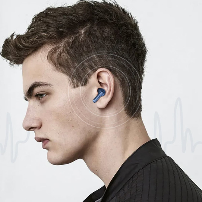 Active noise cancelling wireless earbuds in blue, worn in the ear of a young man with short hair against a neutral background.