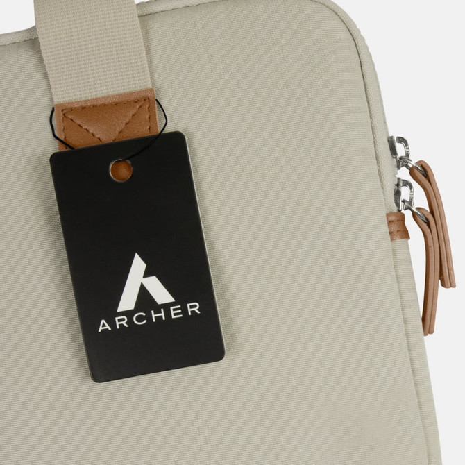 A cream laptop bag featuring a tan accent, with a hang tag displaying a logo.