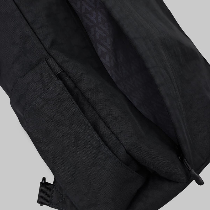 A black Tasman Totepack featuring a textured interior and an exterior pocket. Includes a logo detail.