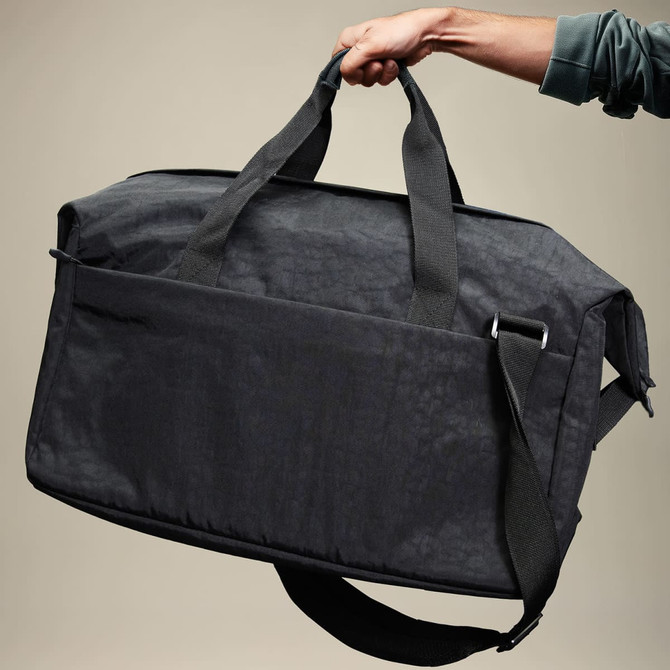 A black duffle bag with dual handles and a shoulder strap, featuring a front pocket and a brand logo.