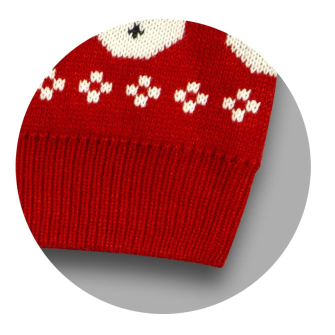A red knitted jumper featuring white patterns, with a ribbed hem and a logo present on the fabric.