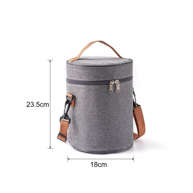 A cylindrical lunch bag in grey fabric, featuring a zip closure and a detachable shoulder strap. It has a handle for easy carrying.