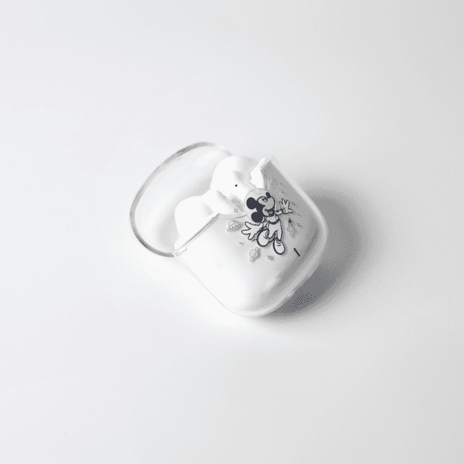 A pair of white noise cancellation earphones in a case featuring a playful design and a logo.