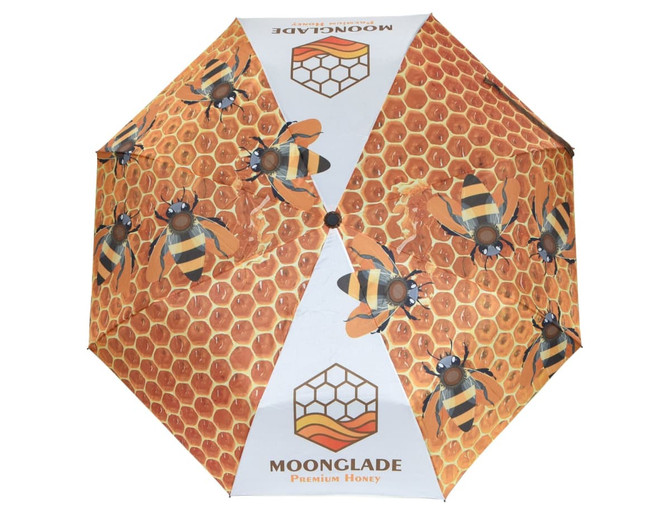 A full-colour umbrella featuring a honeycomb design with bees. Includes a logo and a vibrant colour palette.