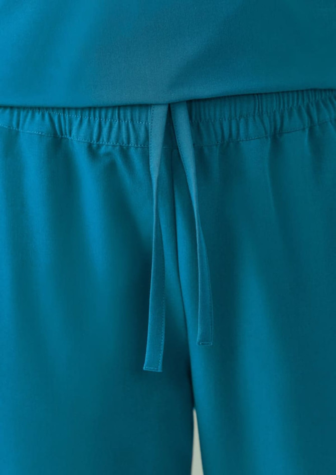 Teal women's jogger scrub pants featuring an elastic waistband and tie detail. The fabric appears soft and comfortable.