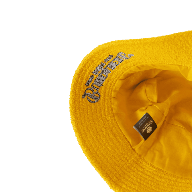 A yellow Terry Bucket Hat with a textured surface and an inner lining. It features a logo inside.