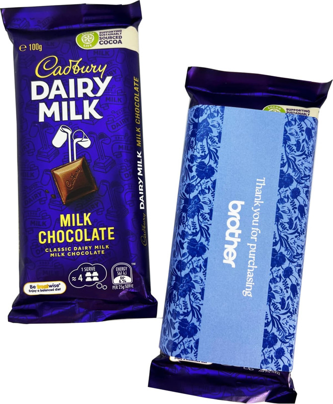 A Dairy Milk chocolate bar in a purple wrapper, featuring a decorative sleeve. The bar weighs 100g. A Dairy Milk chocolate bar in a purple wrapper, featuring a decorative sleeve. The bar weighs 100g.