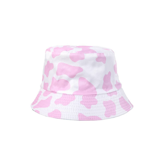 A pink and white cow print bucket hat with a wide brim and soft fabric. Features a branding logo on the side.