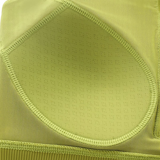 A close-up of a light green women's zip-front racerback yoga crop bra tank featuring textured detailing and a logo.