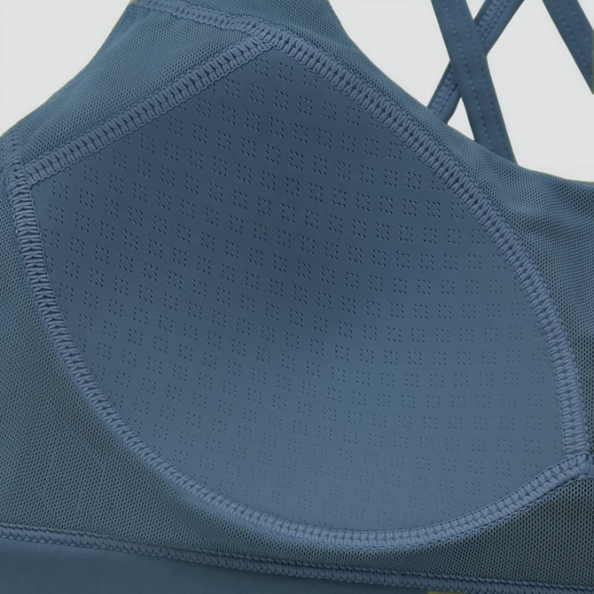 A blue women's cross back yoga crop bra tank featuring a textured design and a subtle logo.