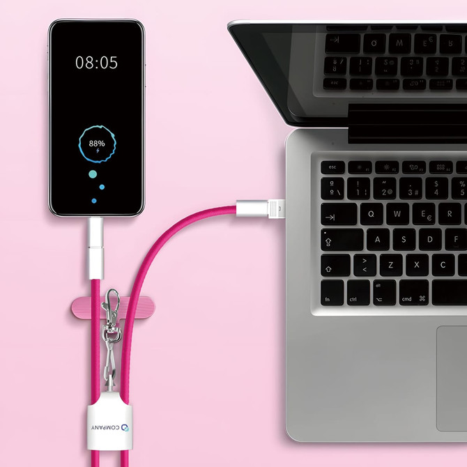 A pink 4-in-1 charging phone lanyard connected to a laptop and a smartphone displaying battery percentage.