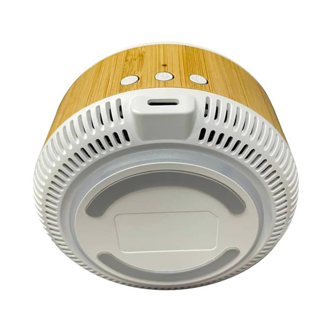 A wireless charging speaker with a bamboo exterior and a white base, featuring buttons on top and a port for charging.