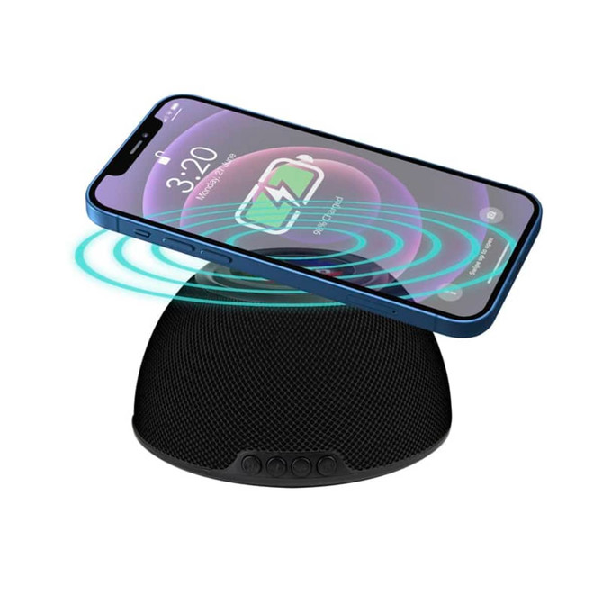 A black wireless charging speaker with a smartphone placed on top, displaying charging indicators.