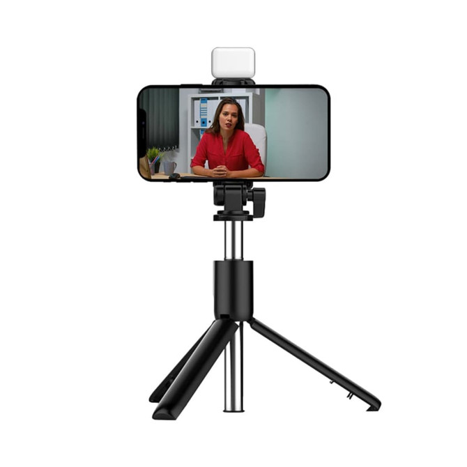 A black LED selfie stand with a tripod base, holding a smartphone displaying a video call.