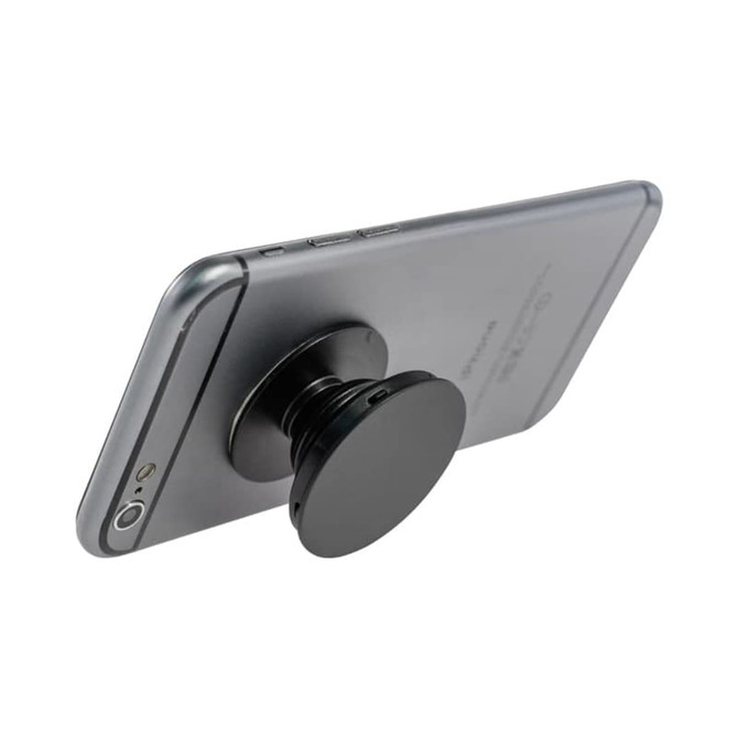 A black phone stand attached to the back of a silver smartphone. The stand has a circular shape.