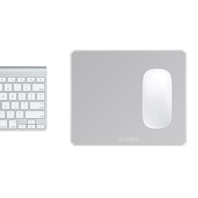 A silver alumina mouse pad with a glossy white surface positioned next to a light grey keyboard.