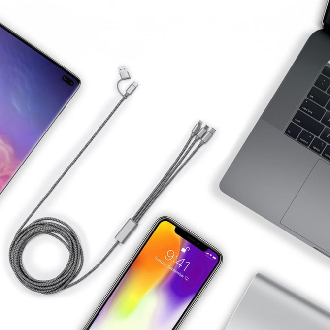 A grey charging cable with multiple connector types, alongside a smartphone and laptop on a white background.