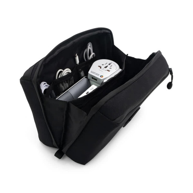 A black toiletry bag with compartments containing cables, a travel adapter, and other accessories.