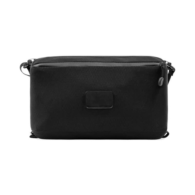 A black toiletry bag featuring a sleek design and a logo, with dual zippered compartments.