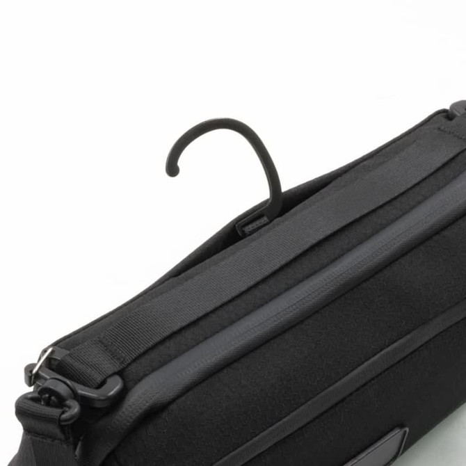 A black toiletry bag featuring a hook for hanging and a sleek design, brand logo visible.