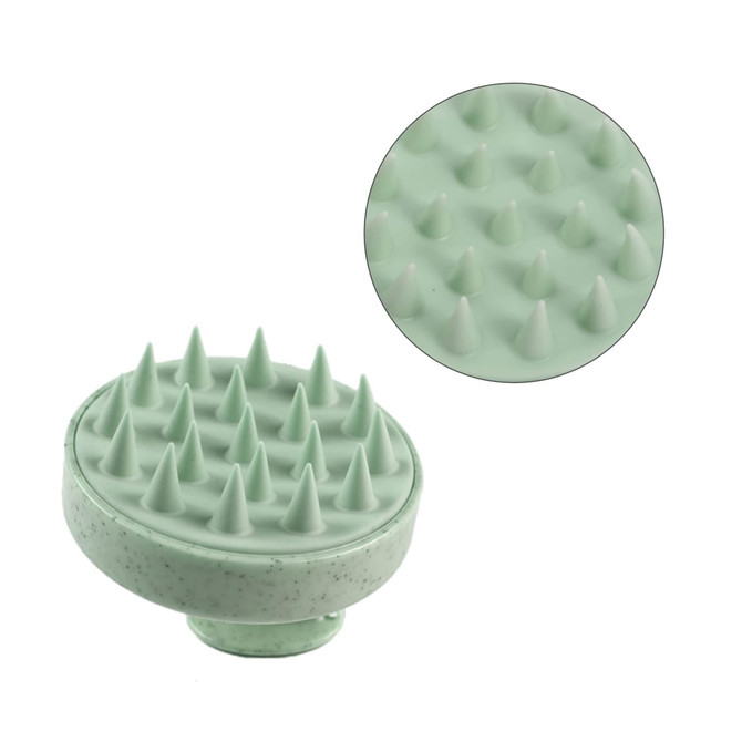 A green hair scalp massager with textured spikes for stimulating the scalp, featuring a circular design.