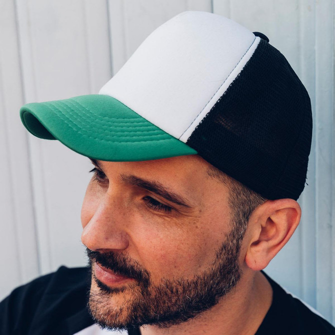 A trucker cap featuring a green brim, white front panel, and black mesh sides, with a logo on the front.