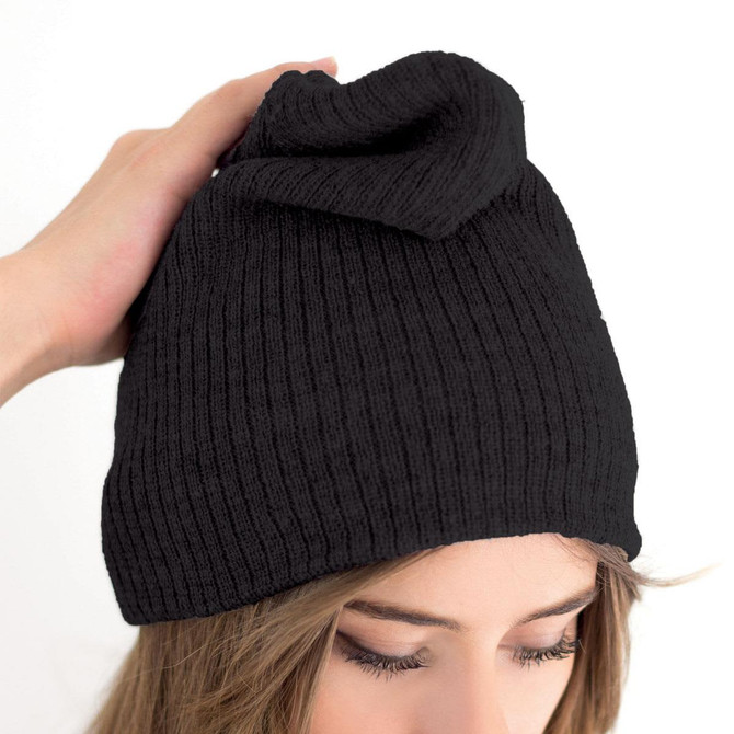 A black beanie with a unique fold at the top, held by a person's hand. It features a logo.