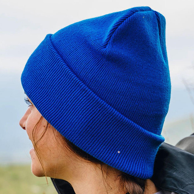 A blue beanie with a pointed top, featuring a ribbed texture and a logo.