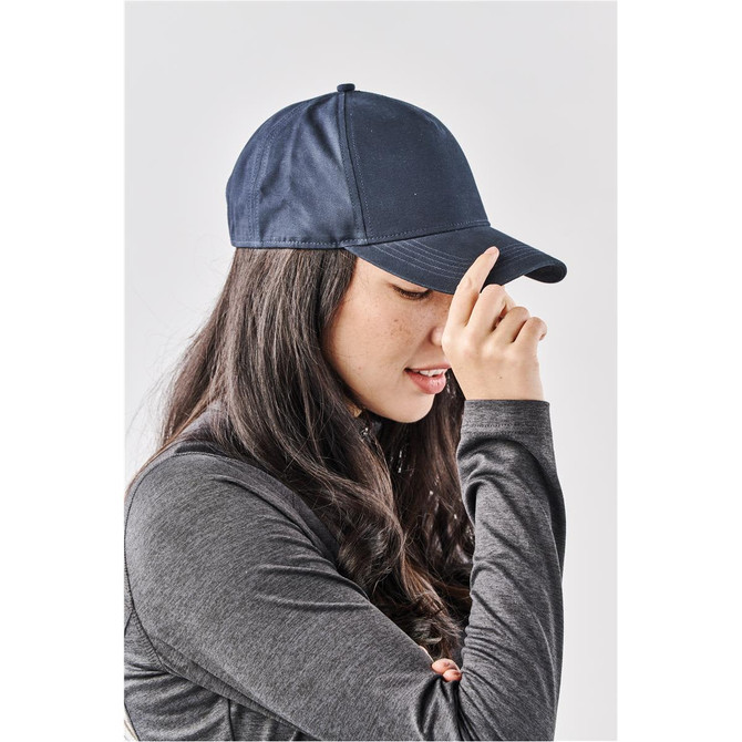 A navy Explorer Cap worn by a woman with long, dark hair, showcasing a side profile and a curved brim.