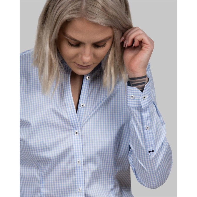 A button-up shirt in light blue check pattern with a collar and long sleeves, featuring subtle branding on the cuff.